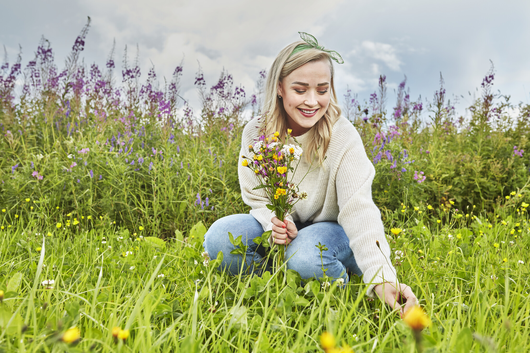 Picture of ostomy user Stina picking up flowers